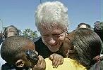 Former President Bill Clinton gets a kiss from resident Johnnie Thompson 